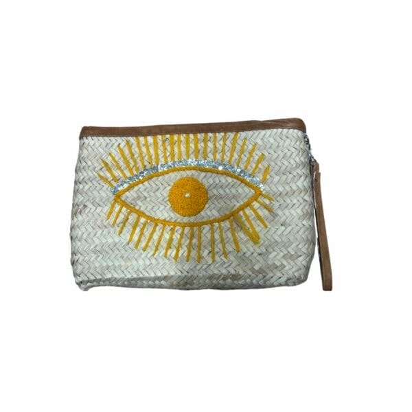 Pochette en raphia avec un oeil jaune et argenté brodé dessus et une anse en cuir . Pochette de la boutique plume magasin de déco aux docks76 à Rouen en normandie